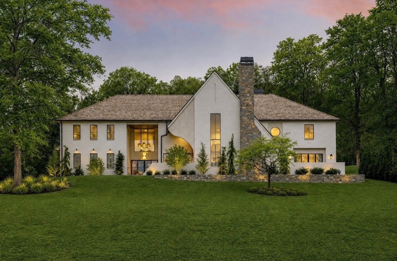 Forest Hills white brick estate with Japanese maple, boxwood, and layered evergreen foundation plantings along stone garden walls