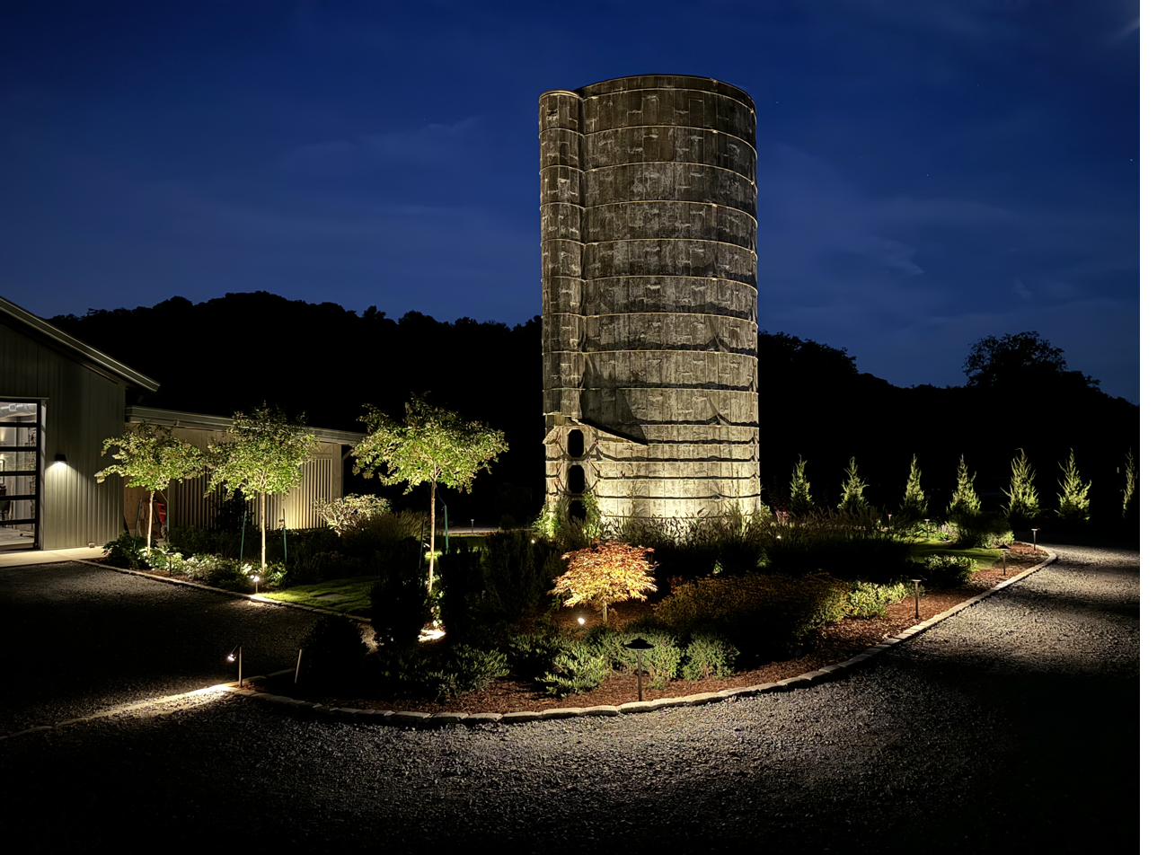 Leiper's Fork silo with landscape lighting illuminating native garden beds at night